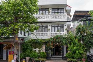 a white house with a balcony on a street at The House 36 in Hoi An