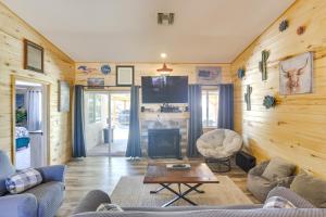 a living room with wooden walls and a couch and a table at Lovely Bullhead City Retreat with Patio and Grill! in Bullhead City