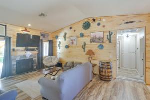 a living room with wooden walls and a couch and a table at Lovely Bullhead City Retreat with Patio and Grill! in Bullhead City