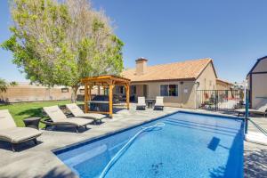 a swimming pool with chairs and a gazebo at Lovely Bullhead City Retreat with Patio and Grill! in Bullhead City