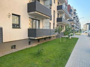 an apartment building with a lawn in front of it at elisio - Bricks Apartment in Braşov