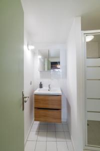 uma casa de banho branca com um lavatório e uma porta em Le cosy de Tonnerre em Tonnerre