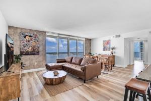 Dreamy Oceanfront Highfloor Corner Unit 2and2 plus Den في ميامي: غرفة معيشة بها أريكة وطاولة