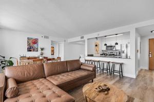 Dreamy Oceanfront Highfloor Corner Unit 2and2 plus Den في ميامي: غرفة معيشة مع أريكة بنية وطاولة