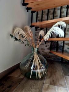 a glass vase with some dried plants in it at Gite de l'Archerie classé 4 étoiles, 9 personnes in Saint-Lambert-la-Potherie +38 photos