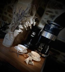 a table with two cups and a coffee maker at Gite de l'Archerie classé 4 étoiles in Saint-Lambert-la-Potherie