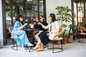 drie vrouwen aan een tafel wijn drinken bij Hotel San Fernando in Mexico-Stad