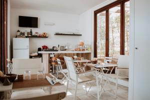 a kitchen and dining room with white chairs and tables at Signuria Dimora Esclusiva in Lecce