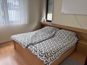 a bedroom with a bed with a black and white comforter at Vakantiewoning Paula Sauerland in Schmallenberg