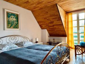 a bedroom with a large bed with a wooden ceiling at Domki nad stawami - Pommernhof in Ustronie Morskie
