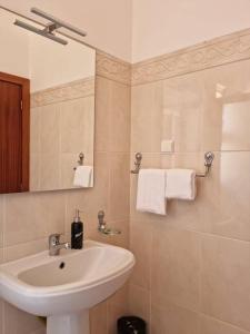 a white bathroom with a sink and a mirror at Villa&Damata in Água de Pena