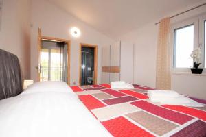 a bedroom with a bed with a red and white blanket at Villa Anna in Medulin