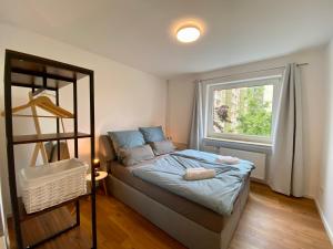 um pequeno quarto com uma cama e uma janela em LEMON - 4 Per - Garage - 65 Zoll em Braunschweig