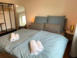 una camera da letto con un letto e asciugamani di LEMON - 4 Per - Garage - 65 Zoll a Braunschweig