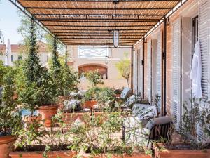 eine Außenterrasse mit Topfpflanzen und einer Pergola in der Unterkunft Paradis Pietrasanta in Pietrasanta