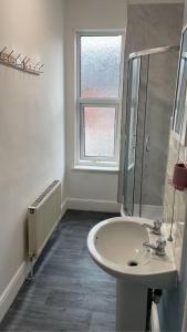 a white bathroom with a sink and a window at Transformative housing Laurie avenue in Nottingham