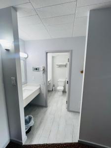 an empty bathroom with a toilet and a sink at Lively Inn and Suites - Sudbury in Naughton