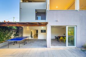una casa con tavolo da ping pong su un patio di Villa Leandra near Omiš, private pool a Tugare
