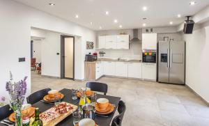 una cucina e una sala da pranzo con un tavolo con del cibo sopra di Villa Leandra near Omiš, private pool a Tugare