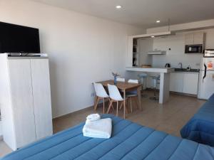 a bedroom with a blue bed and a kitchen at M O R A Home & Office in Cipolletti