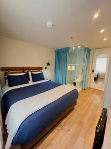 una camera da letto con un grande letto con cuscini blu di Grace Chapinero a Bogotá
