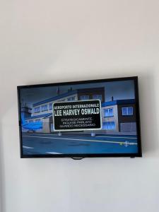 a flat screen tv sitting on a wall at Airport Seaview Rooms in Naples