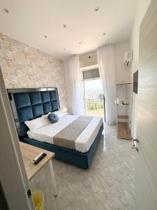 Airport Seaview Rooms في نابولي: غرفة نوم بسرير كنج وطاولة