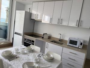 贝尼多姆Penthous vue sur mer à Benidorm的厨房配有白色橱柜和一张带餐具的桌子。