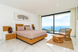 ein Schlafzimmer mit einem Bett und einem großen Fenster in der Unterkunft Villa Rocha in Arco da Calheta in Arco da Calheta + 44 Fotos