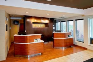 a lobby with a reception desk in a building at Courtyard by Marriott Lansing in Lansing