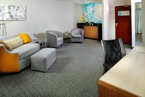 una sala d'attesa con divano e sedia di Courtyard by Marriott Lansing a Lansing