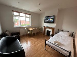 1 dormitorio con cama, mesa y TV en 2 bedroom apartment, 5 minutes from city centre, en Newcastle