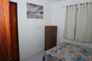 a bedroom with a bed and a picture on the wall at Canoa Quebrada House in Canoa Quebrada