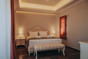 a bedroom with a bed with a bench in it at Epavli Alexandros Luxury Villa in Vourvourou