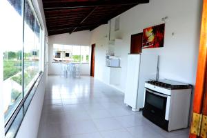 a kitchen with white appliances and a large window at Canoa Quebrada House in Canoa Quebrada