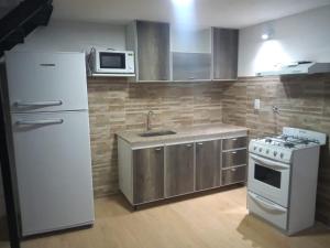 a kitchen with a white refrigerator and a stove at Aire de mar in Mar del Plata