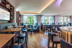 a restaurant with tables and chairs and a bar at Courtyard by Marriott Hamburg Airport in Hamburg