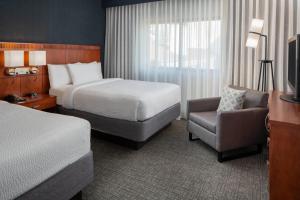 赫恩登的住宿－Courtyard by Marriott Dulles Airport Herndon/Reston，配有一张床和一把椅子的酒店客房