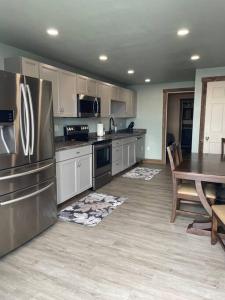 a kitchen with a table and a stainless steel refrigerator at ParkWay Yellowstone Guest House #7 in Gardiner