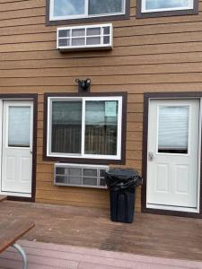 una casa con dos puertas blancas y un cubo de basura en ParkWay Yellowstone Guest House #7 en Gardiner