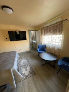 1 dormitorio con cama, mesa y TV en ParkWay Yellowstone Guest House #7 en Gardiner