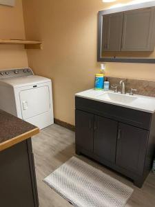 a kitchen with a sink and a washing machine at ParkWay Yellowstone Guest House #7 in Gardiner