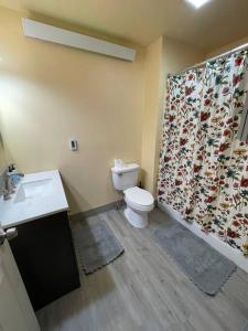 y baño con aseo y cortina de ducha. en ParkWay Yellowstone Guest House #7 en Gardiner