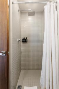 Una ducha con una cortina de ducha blanca en un baño. en Unique 1BR in Cuauhtémoc, en Ciudad de México