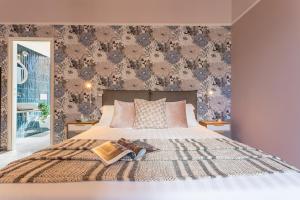- une chambre avec un lit et un mur recouvert de papier peint dans l'établissement 37 Monti Apartment, à Rome