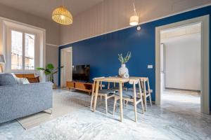 un salon avec une table et un mur bleu dans l'établissement 37 Monti Apartment, à Rome