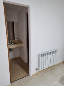 a bathroom with a sink and a radiator in a room at BELLISIMO, Amplio, a solo 100 metros del RIO, la zona VIP de Rosario!!! in Rosario