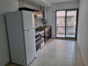a kitchen with a white refrigerator and a tile floor at BELLISIMO, Amplio, a solo 100 metros del RIO, la zona VIP de Rosario!!! in Rosario +23 photos