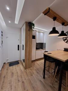 a kitchen and dining room with a wooden table at Apartman 64 Lux in Veliko Gradište