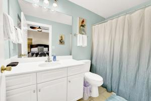 ein Badezimmer mit Waschbecken, Toilette und Spiegel in der Unterkunft Ocean Ritz 1203 in Panama City Beach + 11 Fotos